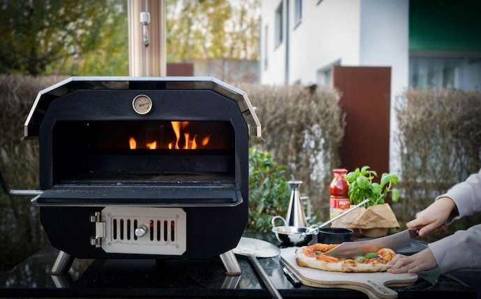 der-merklinger-bobby-im-einsatz,-daneben-eine-pizza,-die-gerade-geschnitten-wird