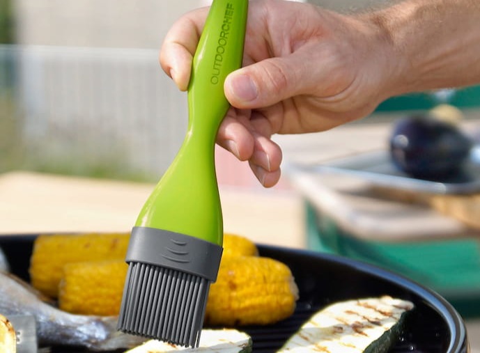 grüner-silikonpinsel-beim-marinieren-von-gemüse