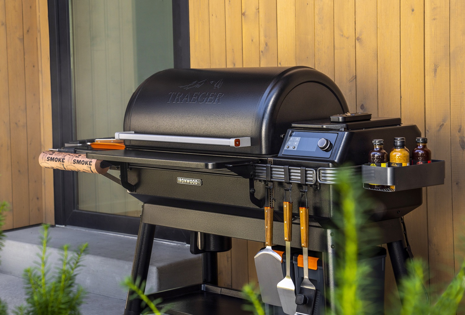 smoker-traeger-ironwood-xl-mit-grillbesteck-vor-einer-hölzernen-hauswand