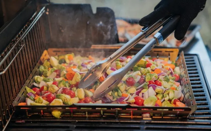eckiger-edelstahlkorb-mit-gemüse-auf-einem-grill
