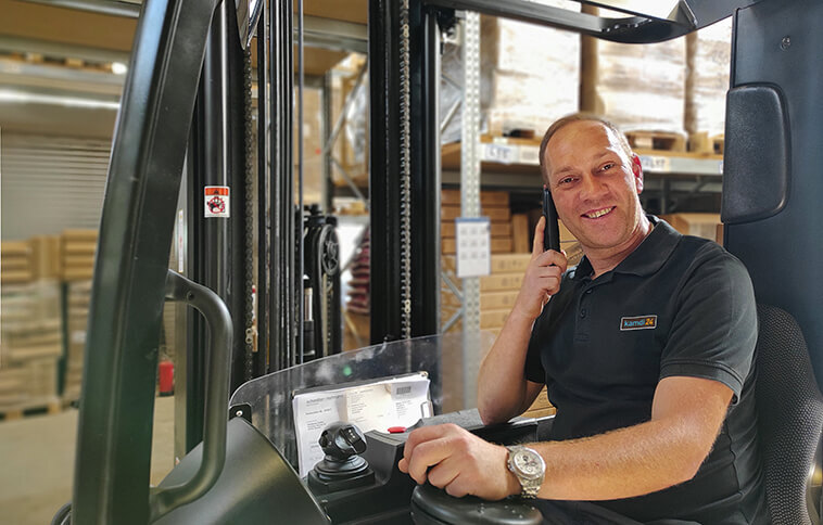Mitarbeiter im Lager mit Gabelstapler Mann telefoniert in einem Gabelstapler