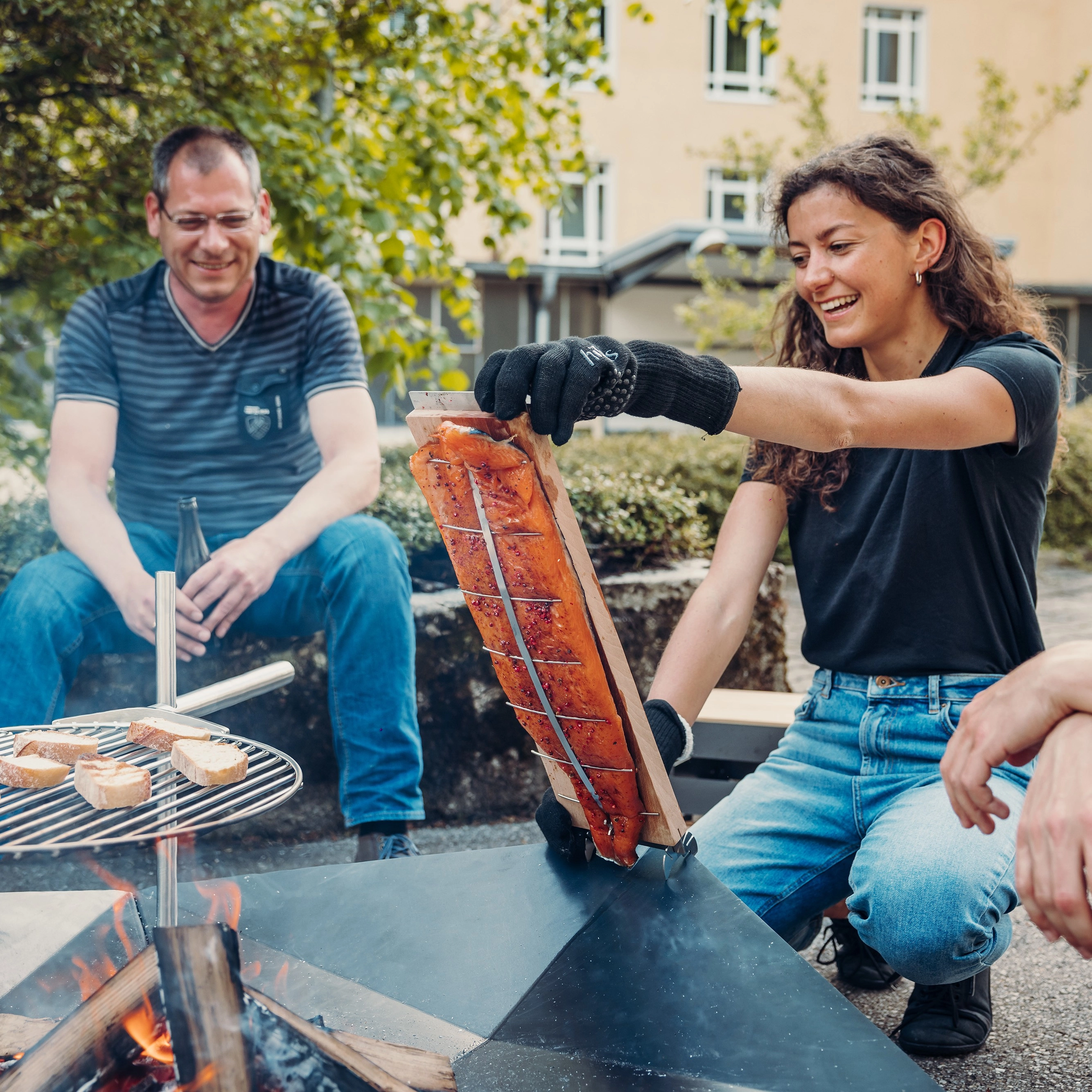 frau-mit-grillhandschuhen-und-einem-flammlachsbrett