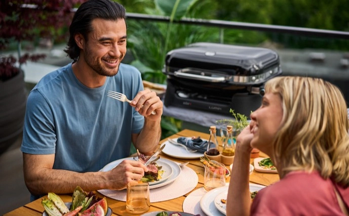 paar-an-einem-sommerabend-auf-dem-balkon-mit-einem-weber-lumin-elektro-tischgrill