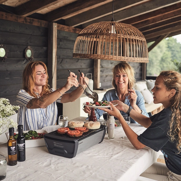 familie-am-tisch-mit-dem-enders-holzkohle-tischgrills-aurora-grey