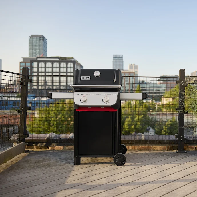 weber-spirit-gasgrill-auf-einer-terrasse-im-urbanen-ambiente---blick-über-die-stadt