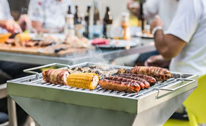 thüros-säulengrill-im-einsatz-im-hintergrund-ein-tisch-mit-gästen