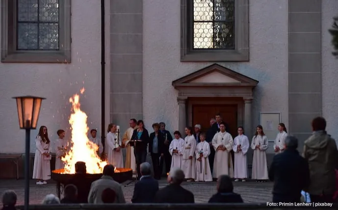 pastoren-und-gläubige-vor-einer-kirche-am-osterfeuer,-das-in-einer-feuerschale-brennt
